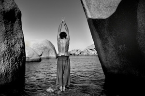 Yoga posture on a rock in a mountain lake
