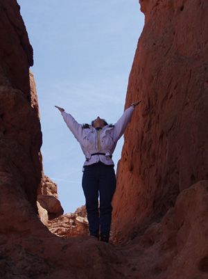 Arms spread wide in a mountain valley